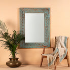 Carved mango wood mirror Anila with turquoise finish and hand-carved floral motifs. A bold and colorful addition to vintage home decor and Indian-inspired interiors.