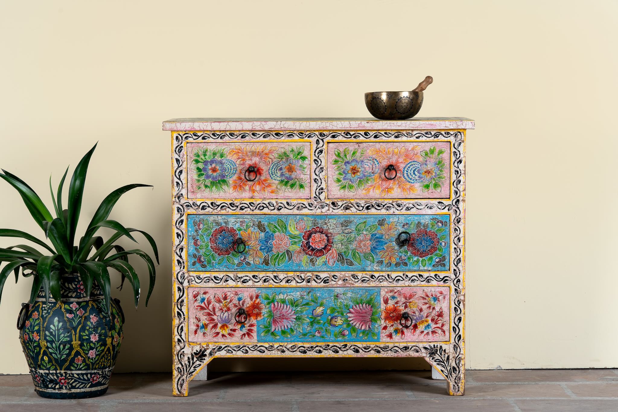 Hand-painted chest of drawers Anjana made from reclaimed wood, featuring four drawers with floral motifs in vibrant colours. A standout piece of sustainable furniture and painted wooden artistry.