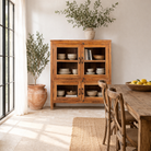 Lifestyle image of a reclaimed teak wood display cabinet with four glass-panelled doors – wooden showcase cabinet crafted as sustainable furniture with timeless appeal.