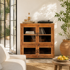 Lifestyle image of a reclaimed teak wood display cabinet with four glass-panelled doors – wooden showcase cabinet crafted as sustainable furniture with timeless appeal.
