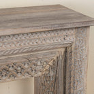 Close up image of a carved console table made from reclaimed teak with antique Indian floral and geometric detailing, 160 × 40 × 90 cm.