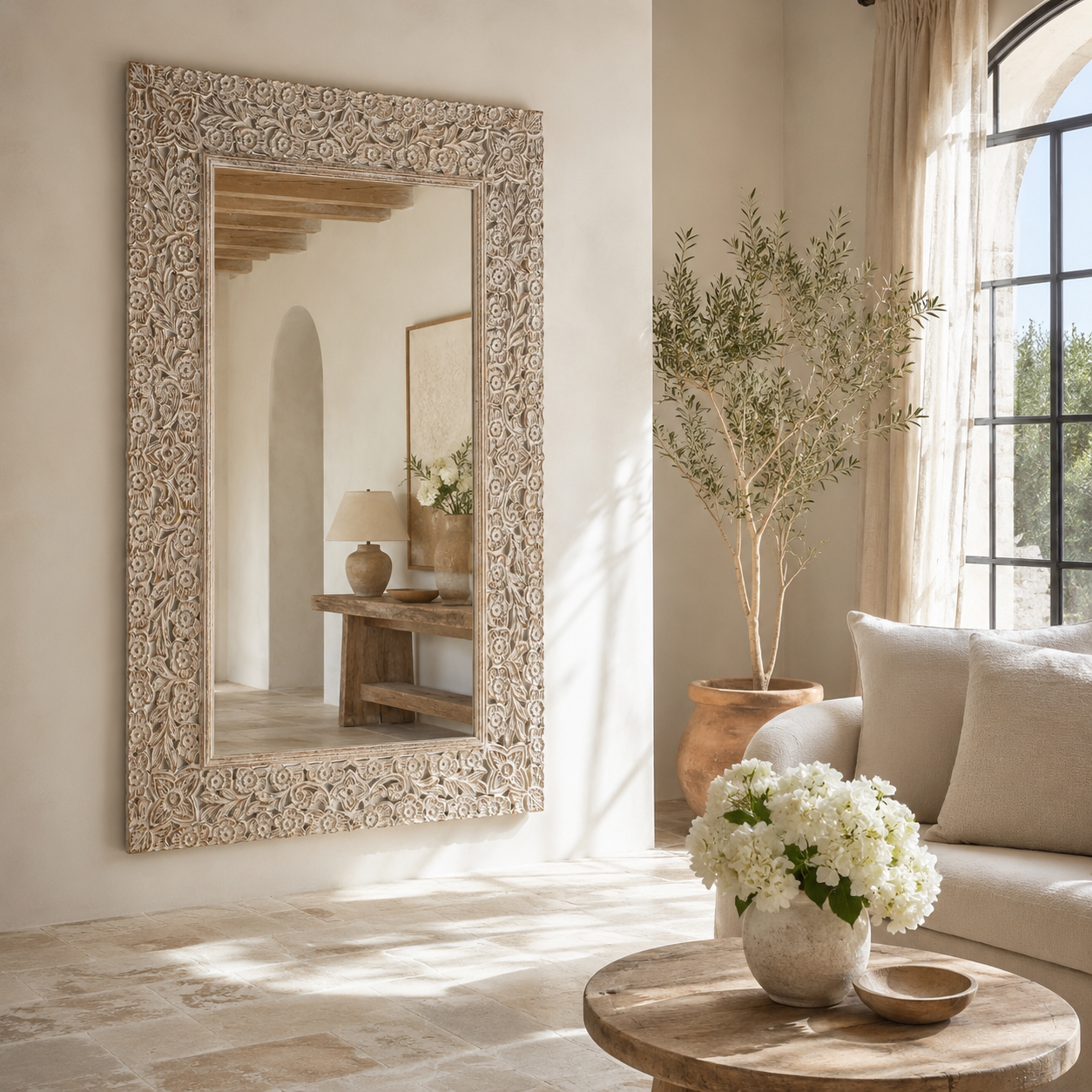 Lifestyle image of a carved wood mirror Antaka made from solid mango wood with hand-carved frame. A unique piece of living room furniture and boho wall décor that adds light and rustic elegance to any space.
