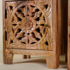 Close up picture of a pair of mango wood bedside tables with floral and geometric carvings; natural finish mango wood furniture ideal for bedroom furniture, 45 × 65 × 35 cm.