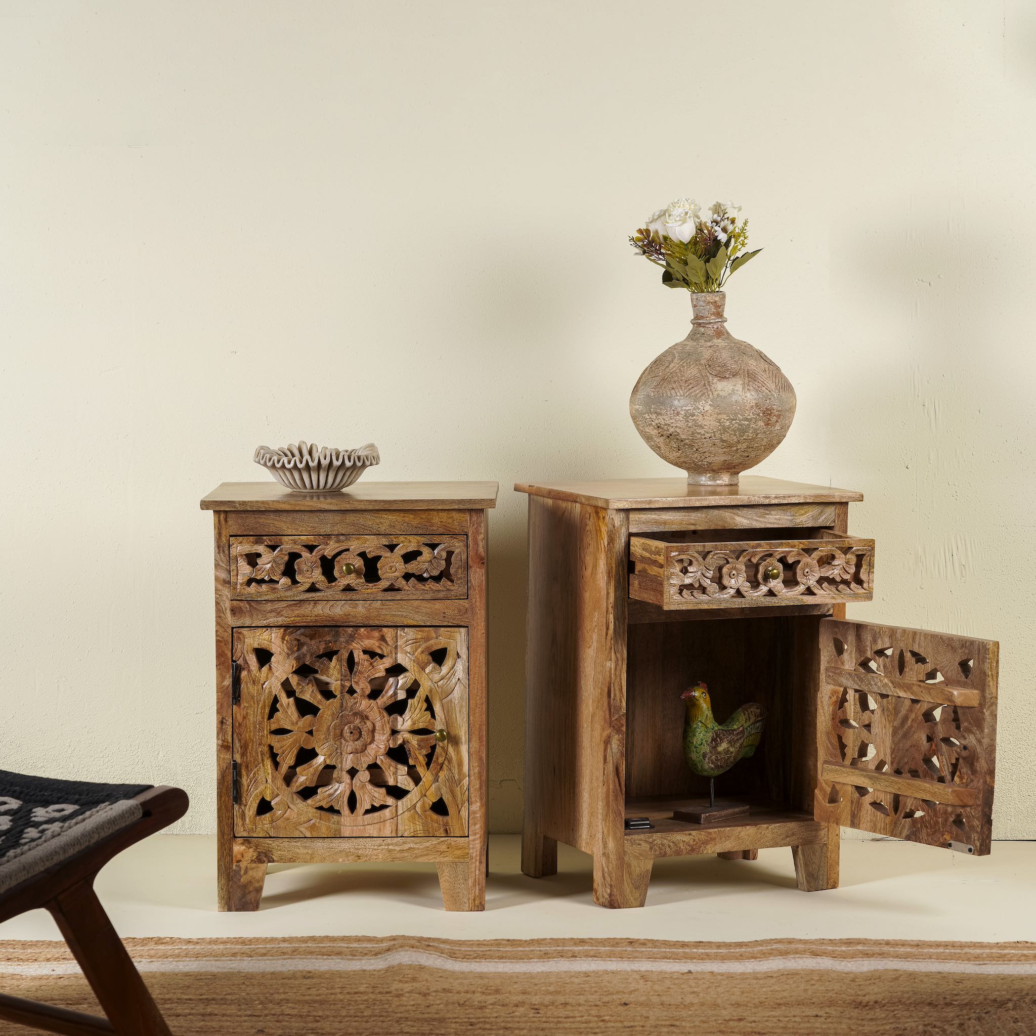 Open door picture of a pair of mango wood bedside tables with floral and geometric carvings; natural finish mango wood furniture ideal for bedroom furniture, 45 × 65 × 35 cm.