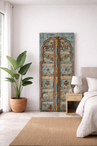 Lifestyle imagination of a hand‑painted antique Indian old door panel Prabhaat with mythological scenes, crafted as unique Indian furniture and wall decoration. A vibrant teak wood piece perfect for vintage and artistic interiors.