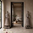 Lifestyle image of an antique Indian wooden temple guardian figure with weathered patina, styled beside a black-framed door in a modern living room.