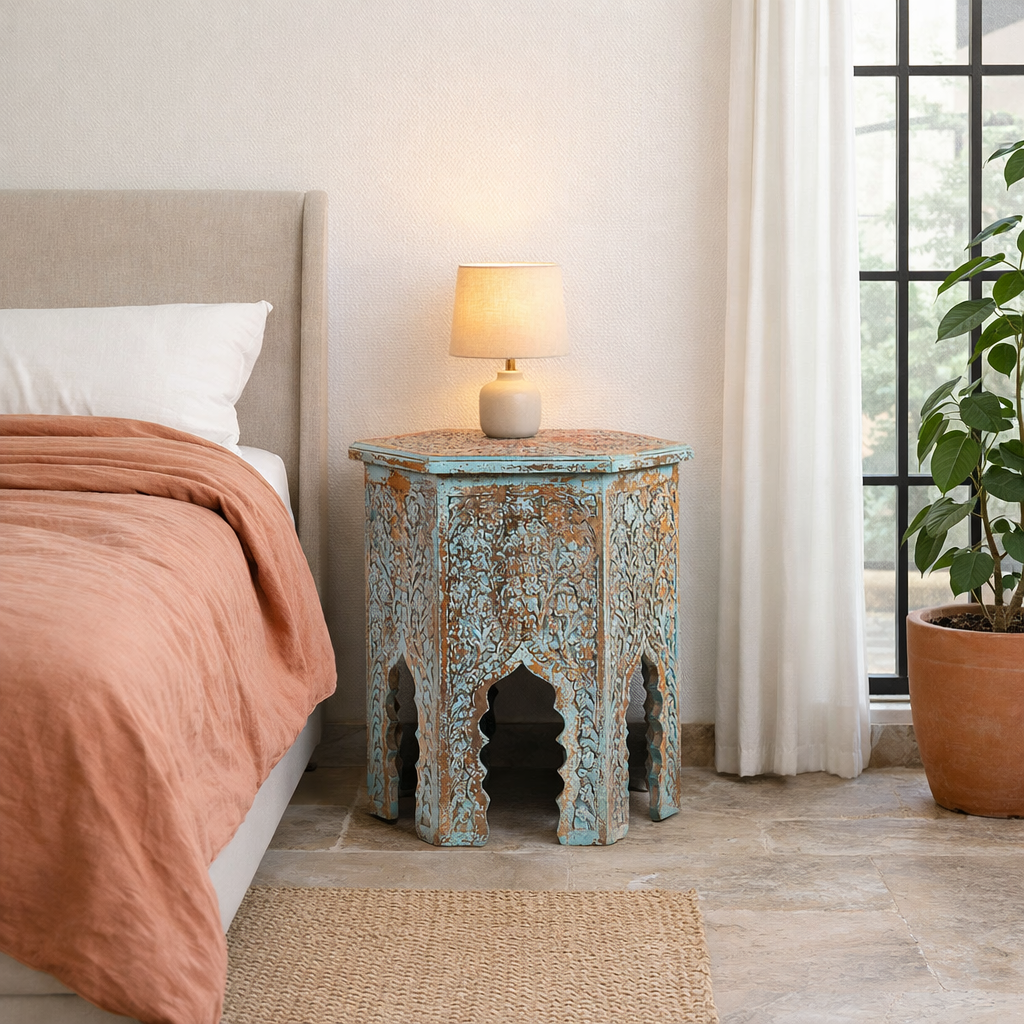 Decorative side table with arched design next to a bed in a bedroom.