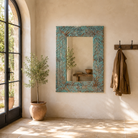 Lifestyle imagination of a carved mango wood mirror Anumati with floral hand-carving and distressed finish. A unique Indian furniture piece perfect for vintage home decor and bohemian interiors.