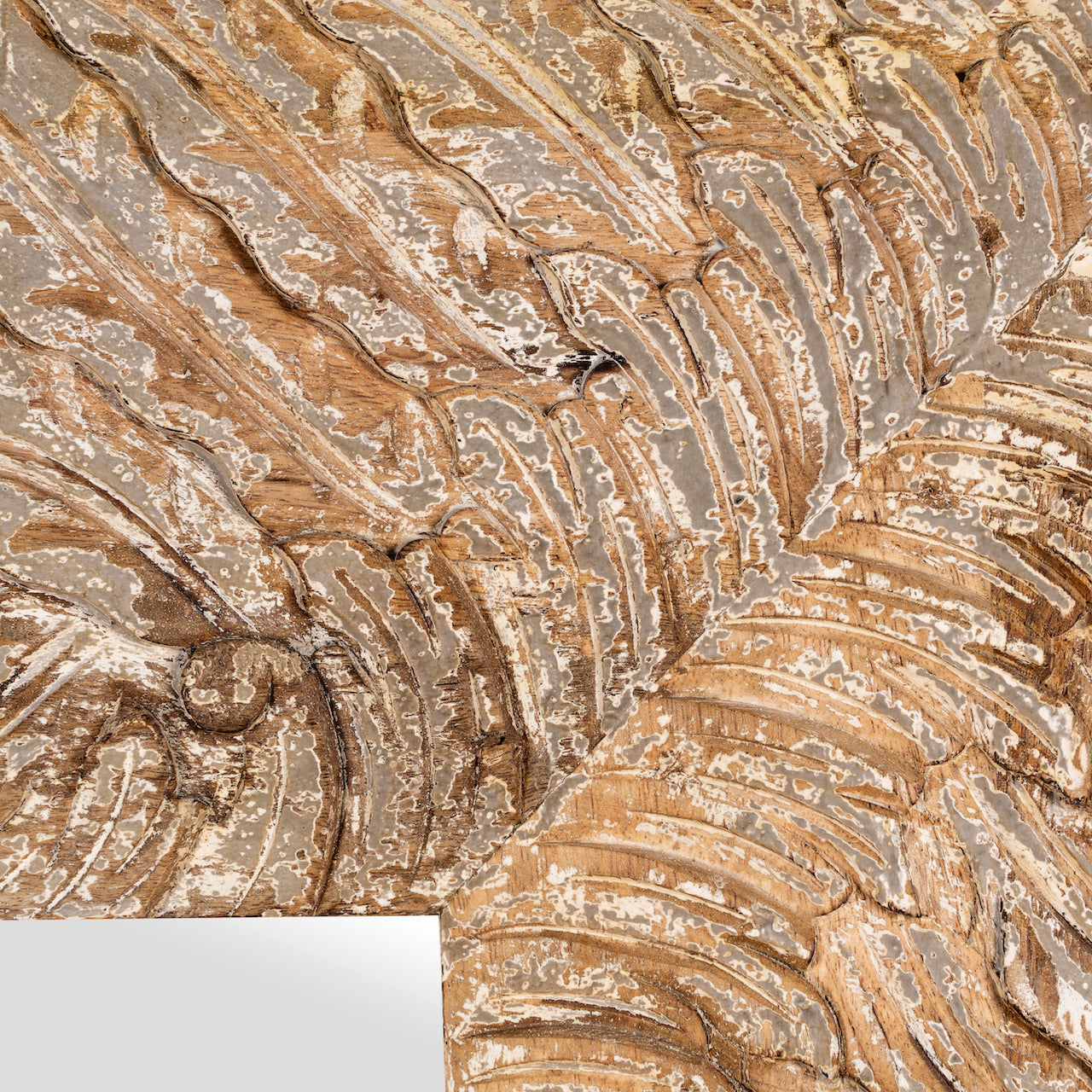 Close up image of a carved mango wood mirror Anumati with floral motifs and distressed finish. A handcrafted Indian furniture piece perfect for vintage home decor and artisanal interiors.