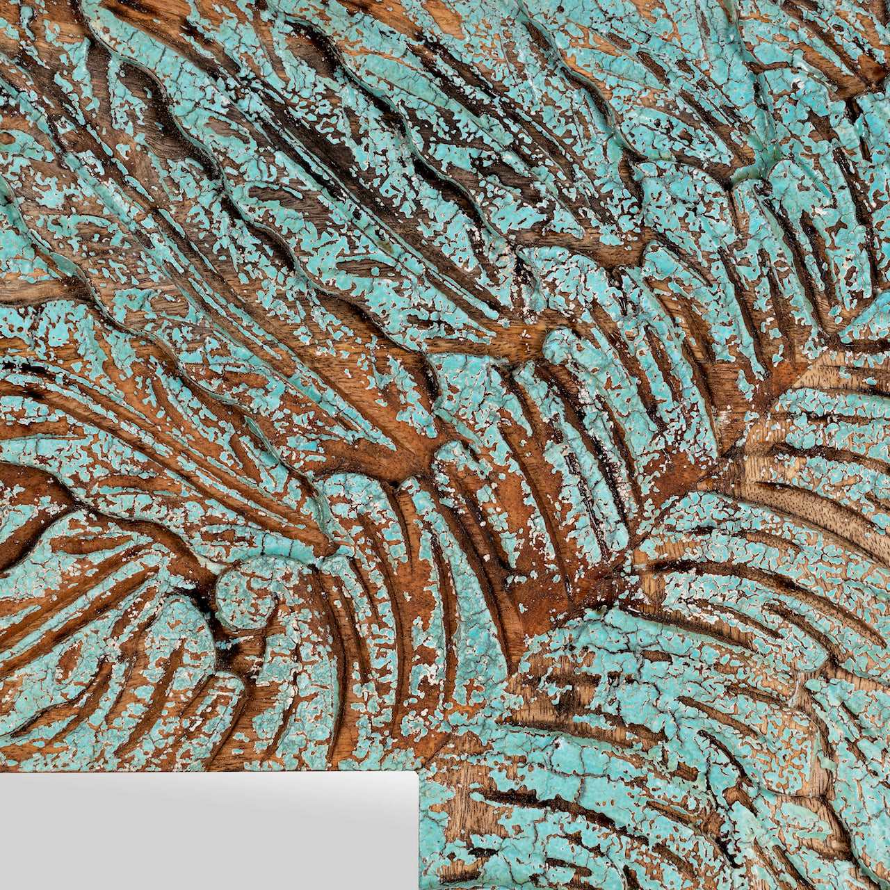 Close up image of a carved mango wood mirror Anumati with floral hand-carving and distressed finish. A unique Indian furniture piece perfect for vintage home decor and bohemian interiors.