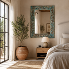 Lifestyle image of a Carved mango wood mirror Anuvinda with turquoise finish and hand-carved detailing. A vibrant vintage home decor piece reflecting traditional Indian craftsmanship.