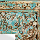 Close up image of a Carved mango wood mirror Anuvinda with turquoise finish and hand-carved detailing. A vibrant vintage home decor piece reflecting traditional Indian craftsmanship.