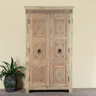 Reclaimed teak wood cabinet Anwika featuring a tall Mediterranean-style frame with hand-carved antique Indian doors. A unique piece of Indian furniture offering character-rich storage and timeless design.