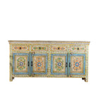 White background image of a hand-painted reclaimed wood cabinet Anwita in Mediterranean Boho style with floral motifs, four drawers, and four doors. A colourful and sustainable statement piece for boho chic living room décor.