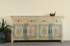 Hand-painted reclaimed wood cabinet Anwita in Mediterranean Boho style with floral motifs, four drawers, and four doors. A colourful and sustainable statement piece for boho chic living room décor.