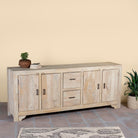 Wooden sideboard Ibiza style with doors and drawers against a beige wall.