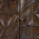 Close up image of a hand-carved mango wood sideboard with brass-plated iron stand—an artisanal, minimalistic furniture piece combining natural warmth and modern elegance.