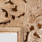 Close up image of a carved mango wood mirror Apsara in white-washed finish with hand-carved floral design. A tall, artisan-crafted piece of Indian furniture ideal for vintage home decor and bohemian interiors.
