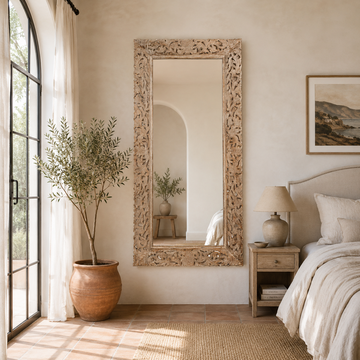 Lifestyle image of a carved mango wood mirror Apsara in white-washed finish with hand-carved floral design. A tall, artisan-crafted piece of Indian furniture ideal for vintage home decor and bohemian interiors.
