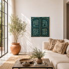 Lifestyle scene with a vintage wall panel crafted from an old teak wood window frame, hand-painted with detailed floral designs in cream, red, and green on a rich teal background, featuring arched upper panels and decorative metal ring pulls.
