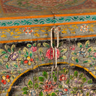 Close up image of a Armaan hand painted reclaimed teak wood storage chest with colourful floral motifs and traditional iron fittings, 151cm wide