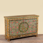 Side angle image of a Armaan hand painted reclaimed teak wood storage chest with colourful floral motifs and traditional iron fittings, 151cm wide
