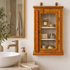 Lifestyle image of a Arnavraj orange hand painted reclaimed wood vintage cabinet with floral motifs glass door and white interior 60cm
