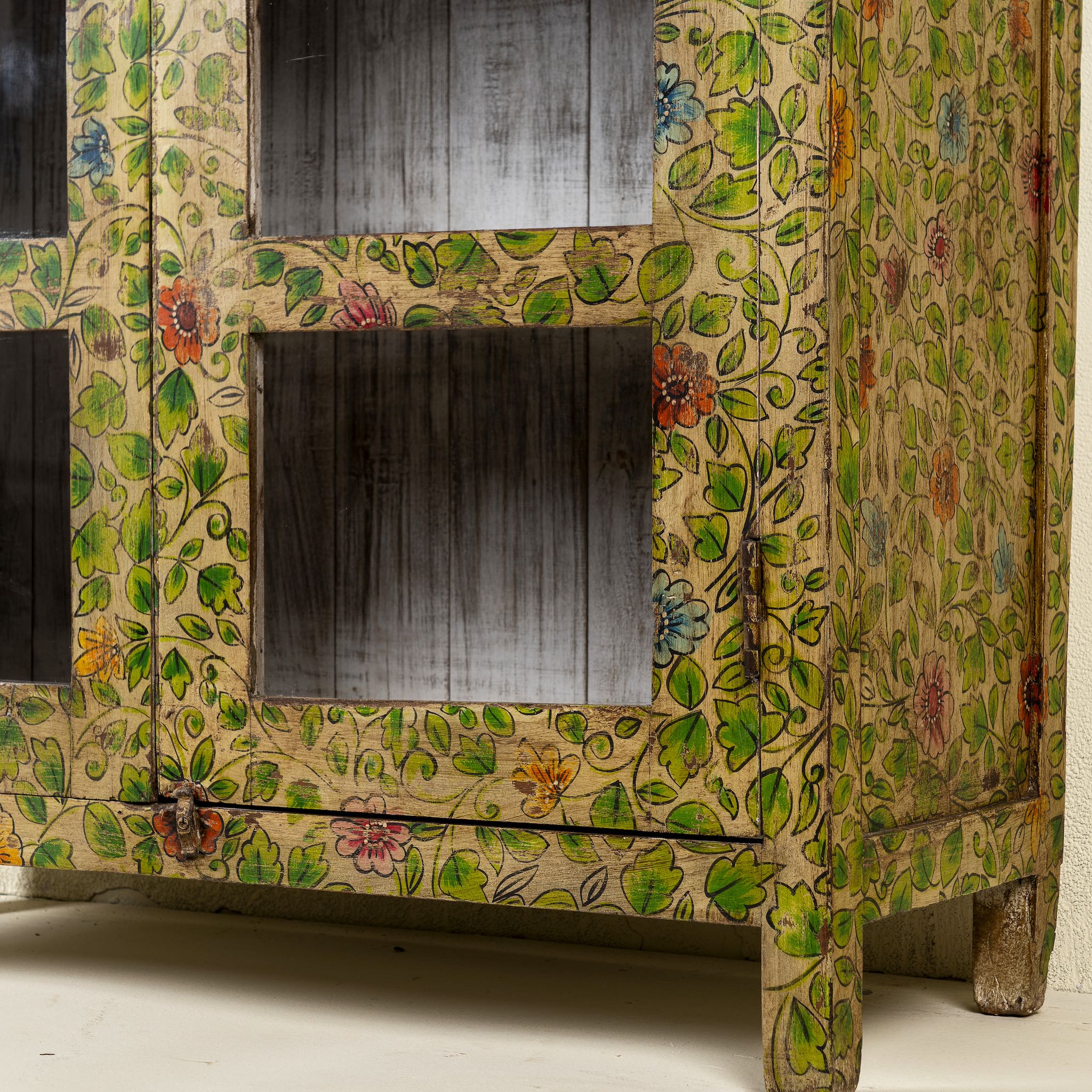 Close up picture  of a hand-painted reclaimed wood showcase cabinet with floral motifs and glass doors, sustainable furniture and vintage home decor style, 96 × 40 × 182 cm.