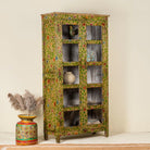 Side angle image of  a hand-painted reclaimed wood showcase cabinet with floral motifs and glass doors, sustainable furniture and vintage home decor style, 96 × 40 × 182 cm.