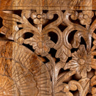 Close up image of a hand-carved mango wood wall panel with floral engravings in natural finish – Arusha model by Om Home & Garden