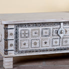 Close up image of a Aryav whitewashed mango wood coffee table chest with decorative iron fittings 116cm