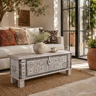 Lifestyle image of a Aryav whitewashed mango wood coffee table chest with decorative iron fittings 116cm