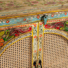 Close up image of a hand painted sideboard Ashara made of mango wood with rattan inserts; Ibiza-inspired boho chic furniture, 120 × 40 × 92 cm.