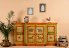 A hand-painted sideboard made of reclaimed wood with vibrant, colorful artistic motifs on the doors and vintage style accents.