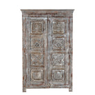 White background image of a reclaimed teak wood cabinet Atharva with floral hand-carved doors in a vintage distressed finish. A sustainable furniture piece ideal for rustic and character-rich living room interiors.