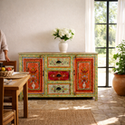 Lifestyle imagination of a sustainable hand painted sideboard made from reclaimed teak wood with floral motifs; bold bohemian furniture, 150 × 45 × 90 cm.