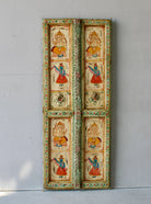 Aum hand-painted teak door panel featuring Goddess Lakshmi and traditional dancers, framed by leafy green carvings—a spiritual and unique Indian wall decoration repurposed from antique teak architecture.
