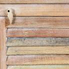 Close up image of a reclaimed teak wood cabinet with slatted door and sandblasted finish, Ibiza-style, 122 × 56 × 40 cm.