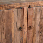 Close up image of a reclaimed wood sideboard Avana in a rustic minimalistic style with multiple cabinets and drawers, showcasing natural wood grain and simple iron handles.