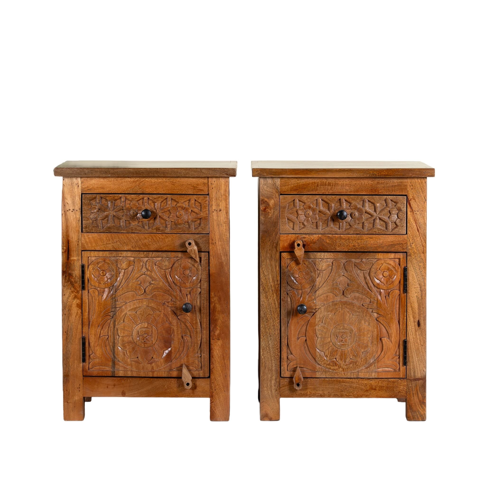 White background image of a pair of handcrafted bedside tables Avi made from solid mango wood, featuring floral hand-carved motifs inspired by Ibiza style. Each table includes a drawer and a cabinet, with a natural wood finish that highlights artisanal detail and organic warmth.