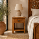 Lifestyle image of a Avni handcrafted mango wood bedside table set of two with drawer and open shelf, solid wood bedroom furniture, 45x35x65cm each.