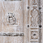 Close up image of a handcrafted cabinet with reclaimed Indian window frame doors, white-washed finish, and iron accents – vintage home decor with teak furniture appeal.