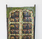 Close up image of a Ayandh hand-painted teak door panel featuring sacred animal motifs and folk figures with a weathered floral frame—a vibrant example of teak door panels and unique Indian wall decoration. 