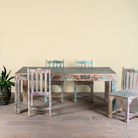 Image of a reclaimed wood dining set Ayla with one vintage table and six rustic chairs. A handcrafted bohemian interior piece combining sustainable materials with artistic, timeworn charm.