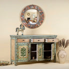 Open doors image of a hand-painted sideboard made from reclaimed wood, featuring three drawers and three cabinet doors adorned with intricate floral borders and tree motifs in earthy green and warm tones, finished in a soft distressed patina for a vintage artisanal look.
