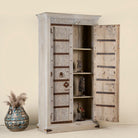 Open door image of a old door cabinet with reclaimed teak doors, floral carvings, and iron accents; artisan teak wood wardrobe with mango wood frame, 100 × 44 × 206 cm.