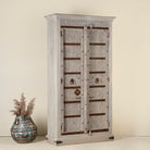 Side angle image of a old door cabinet with reclaimed teak doors, floral carvings, and iron accents; artisan teak wood wardrobe with mango wood frame, 100 × 44 × 206 cm.