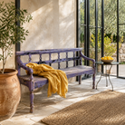 Lifestyle image of a Bagnan reclaimed teak wood bench with distressed shabby chic finish and spindle backrest, 180cm