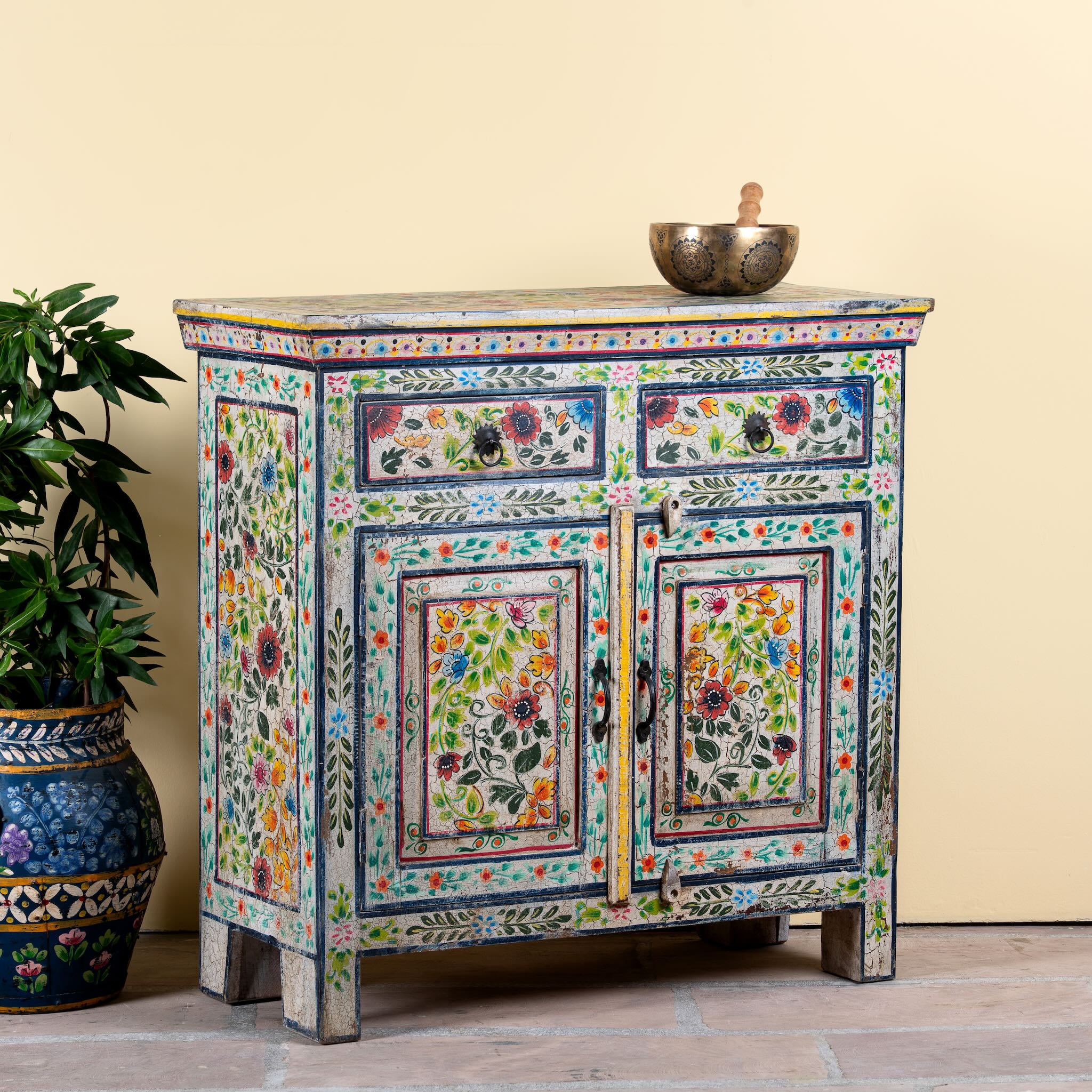 Side angle image of a hand painted reclaimed wood storage cabinet in vintage floral design.
