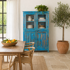 lifestyle image of a refurbished blue teak wood showcase with glass and wooden doors – sustainable dining room furniture crafted from reclaimed teak with vintage flair.